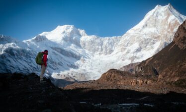 Hiker enjoys a scenic view of a snow-capped mountain.