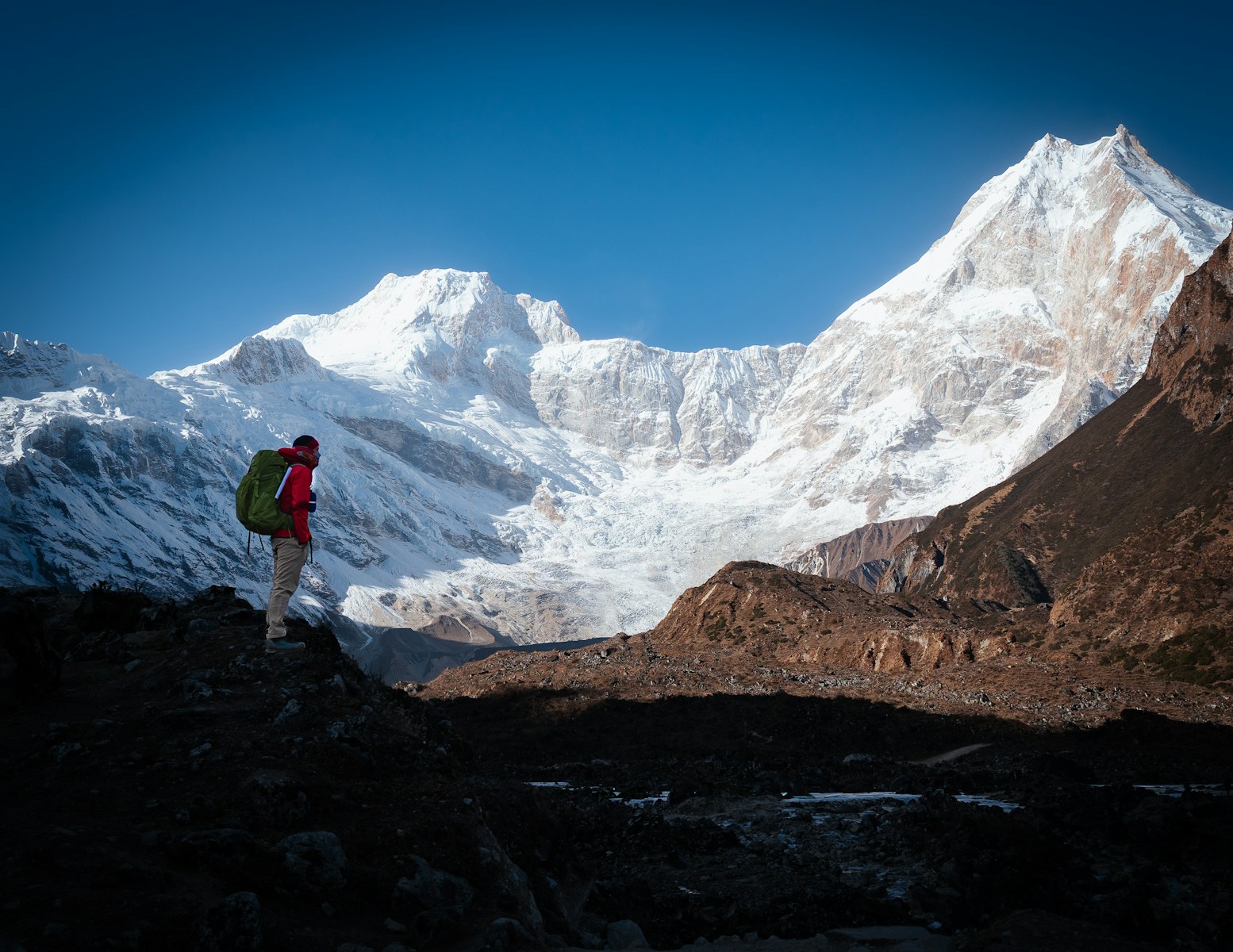 Hiker enjoys a scenic view of a snow-capped mountain.